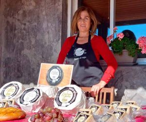 Mujer atractiva vendiendo quesos en un puesto